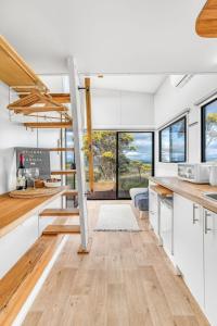 亚拉腊Montara Views 3的厨房配有白色橱柜、木地板和窗户。