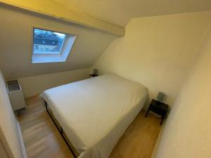 萨尔堡FATHALA - appartement lumineux en dernier étage - face à la gare routière的一间小卧室,配有白色的床和窗户