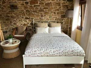 BiescasOne bedroom house with shared pool terrace and wifi at Biescas的一间卧室设有一张床和石墙