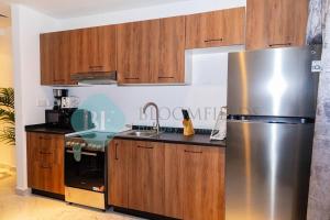 阿布扎比Luxury Studio In Oasis的厨房配有不锈钢冰箱和木制橱柜