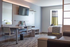West FargoMicrotel Inn & Suites by Wyndham West Fargo Near Medical Center的酒店客房配有书桌和床。