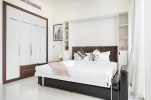 迪拜Modern Studio in Arjan-Dubailand的卧室设有一张大白色的床和大窗户
