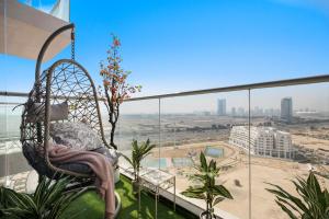 迪拜Modern Studio in Arjan-Dubailand的建筑物阳台上的挂椅