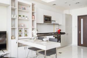 迪拜Modern Studio in Arjan-Dubailand的白色的厨房配有白色的桌子和椅子