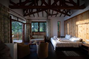 GlacisSunbird Villas的一间卧室配有一张床、一张沙发和窗户。