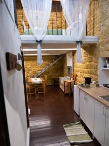 阿格里真托心灵圣殿公寓的一间厨房,配有白色橱柜和一间餐厅
