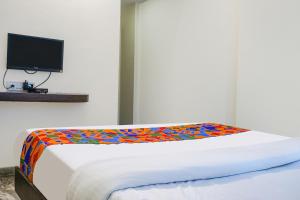 浦那FabHotel Gokul Lodge的一间卧室配有一张带彩色毯子的床