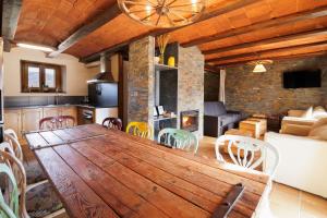 普奇塞达Masia d'en cot的厨房以及带木桌和椅子的客厅。