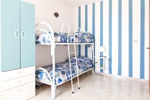 托雷莫泽Casa Tridente - Meravigliosa villa sul mare的蓝色和白色条纹的客房内的双层床