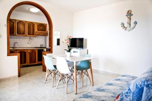 托雷莫泽Casa Tridente - Meravigliosa villa sul mare的厨房以及带桌椅的用餐室。