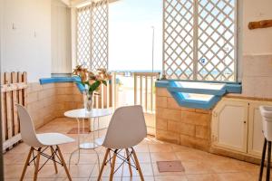 托雷莫泽Casa Tridente - Meravigliosa villa sul mare的窗户客房内的桌椅