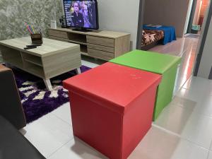 Kota SamarahanThe Time的客厅配有色彩缤纷的家具和电视。