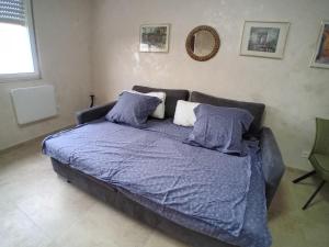 希尔蒂盖姆Superbe T1 - 10 min centre的卧室内的一张带蓝色棉被和枕头的床