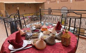 瓦尔扎扎特Riad Parfums de OUARZAZATE的红色桌布上带食物盘的桌子