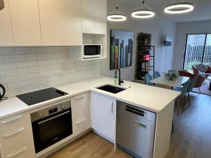 奥克兰布什假期住宿公寓的厨房配有水槽和炉灶 顶部烤箱