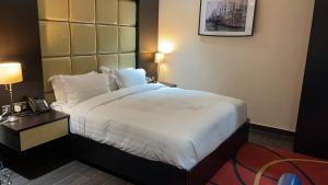 阿布贾Rich Bridge Hotel的配有一张大床和一部电话的酒店客房