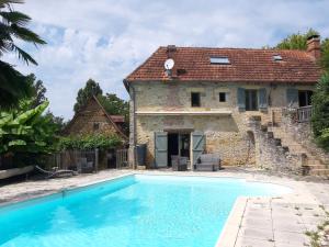 蒙蒂尼亚克Le Chai, gîte de charme avec piscine的大楼前带游泳池的房子