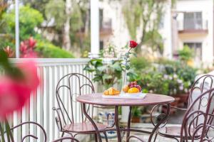 大叻Villa Hoa Ly Đà Lạt的一张桌子上放着花瓶和水果