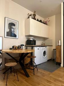 巴黎Appartement Cosy Paris Montmartre的厨房配有桌子和洗衣机。