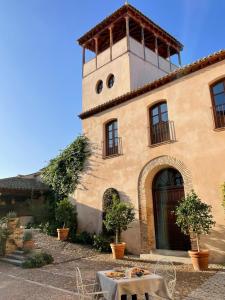 托莱多Casa del Armiño Mansión de la Familia de "El Greco"的前面有桌子的建筑