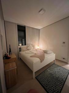 亚喀巴The Oasis Luxury Apartment的一间卧室配有一张白色的床,上面有灯