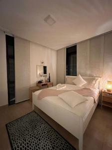 亚喀巴The Oasis Luxury Apartment的卧室配有一张白色大床和黑色地毯。