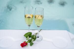 博希尼Hiša Erlah的两杯香槟和一朵玫瑰花在桌子上