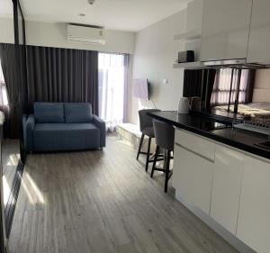 华欣DusitD2 Hua Hin 2- One bedroom with a beautiful view 8的厨房以及带蓝色沙发的起居室。