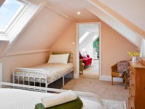 HaytonCartwheel Cottage的阁楼卧室配有床和镜子
