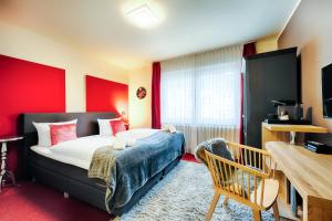 多特蒙德福斯特花园酒店的一间卧室设有一张床和红色的墙壁