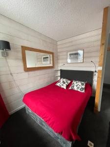 夏蒙尼-勃朗峰Andro的一间卧室配有红色的床和两个枕头
