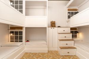 巴塞罗那格雷西亚旅舍的一间卧室设有两张床和白色橱柜。