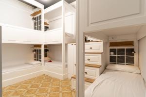 巴塞罗那格雷西亚旅舍的卧室配有带白色橱柜的双层床。
