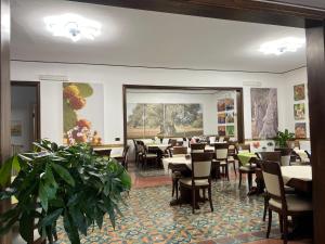 托雷苏达Hotel Villa Giovanna的用餐室配有桌椅和植物