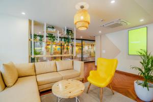 古尔冈Bloom Hotel - Medicity Gurugram, Near Medanta Hospital的带沙发和黄色椅子的客厅