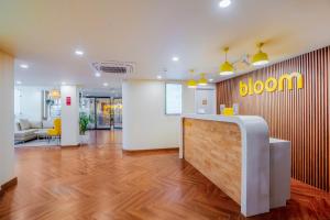 古尔冈Bloom Hotel - Medicity Gurugram, Near Medanta Hospital的办公室,设有前台,墙上有花卉标志