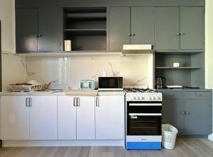 霍巴特Wellesley Mountain House near City的厨房配有白色橱柜和炉灶烤箱。