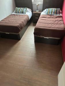 埃普拉特约布里加Comfortable house的客房设有两张床,铺有木地板。