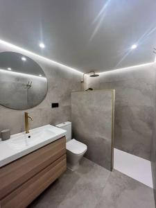 库迪列罗Loft Anfiteatro Cudillero的一间带水槽、卫生间和镜子的浴室