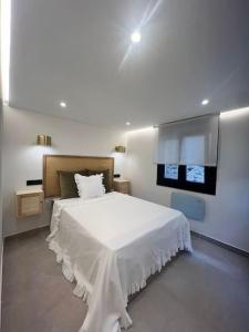 库迪列罗Loft Anfiteatro Cudillero的卧室配有白色的床和电视