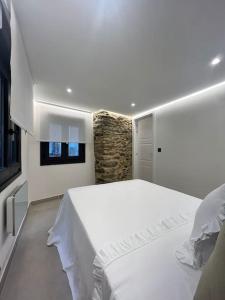 库迪列罗Loft Anfiteatro Cudillero的卧室配有白色的床和窗户。