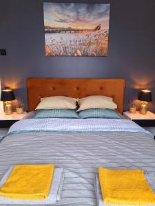 马鲁佩Māja- Linini的一间卧室配有一张带两张黄色毛巾的床