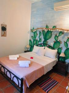 LivadiAMPELIA KYTHIRA的一间卧室配有一张带仙人掌绘画的床