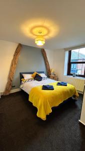 赖厄德Cadwgan House的一间卧室配有一张带黄色毯子的大床