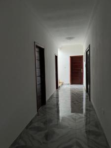 AbomanSerene Hostel的空的走廊,有两扇门,铺着瓷砖地板