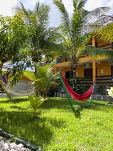 凯鲁Pousada Praia da Cueira的房屋前草地上的两张吊床