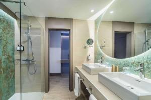 马贝拉Occidental Puerto Banús的浴室设有2个盥洗盆、淋浴和镜子。