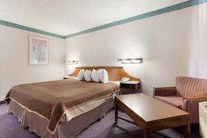 盖洛普盖鲁普旅程住宿的配有一张床和一把椅子的酒店客房
