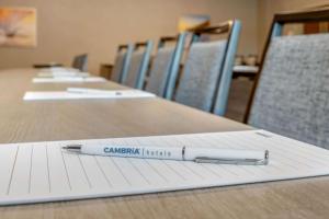 斯波坎Cambria Hotel Spokane Airport的桌子上笔记本上边的笔