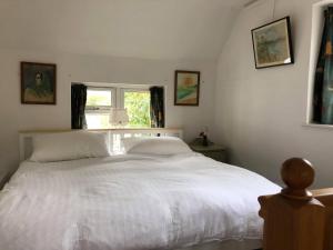 布里德波特Barn Corner的卧室配有一张大白色床和窗户